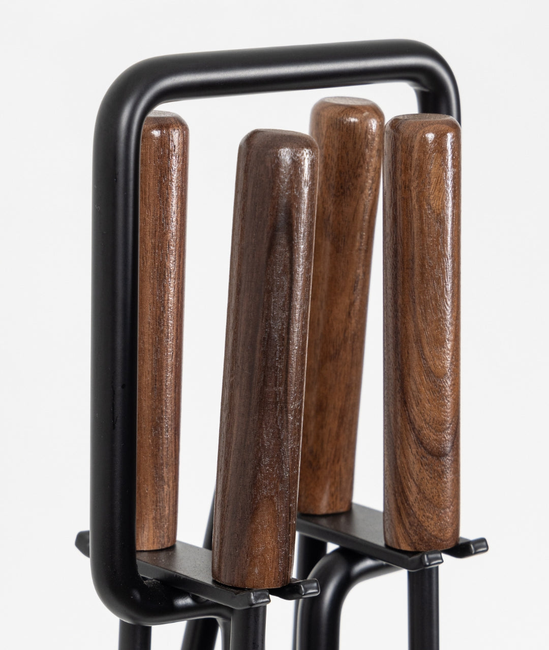 Close-up of Modern Ember fireplace tools with dark walnut wood handles and black metal stand