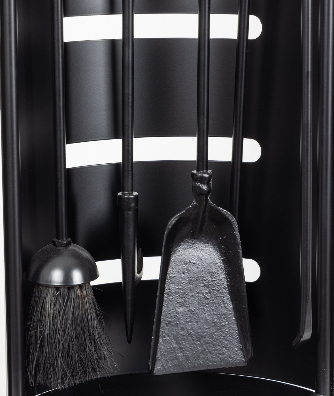Close-up of Modern Ember black fireplace tool set featuring brush, poker, and shovel on curved stand