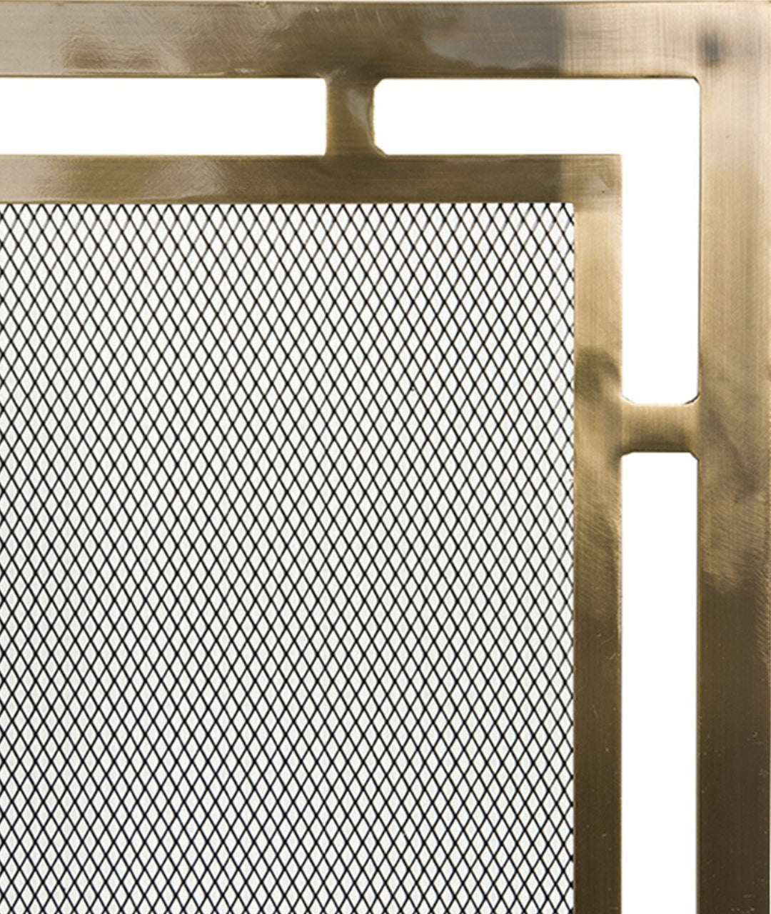 Close-up of Modern Ember brass fireplace screen with geometric frame and fine mesh panel