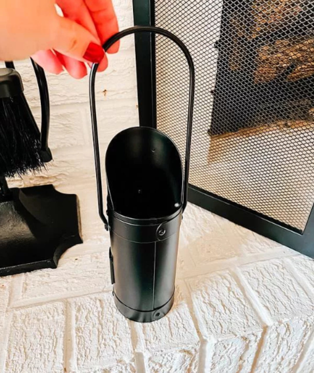 customer image close-up of empty cylindrical match holder in black finish with curved handle, ideal for fireplace use
