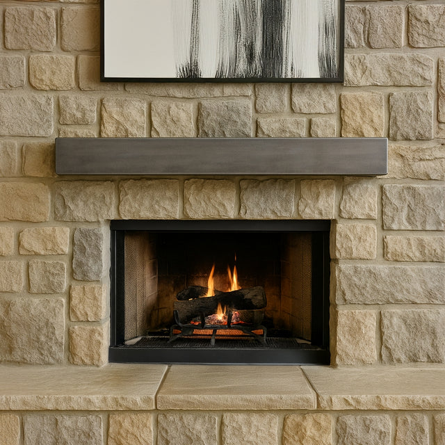 Wide view of a living room fireplace with a fire burning, showcasing the Lustra Metal Mantel Shelf in a silver birch finish mounted above.