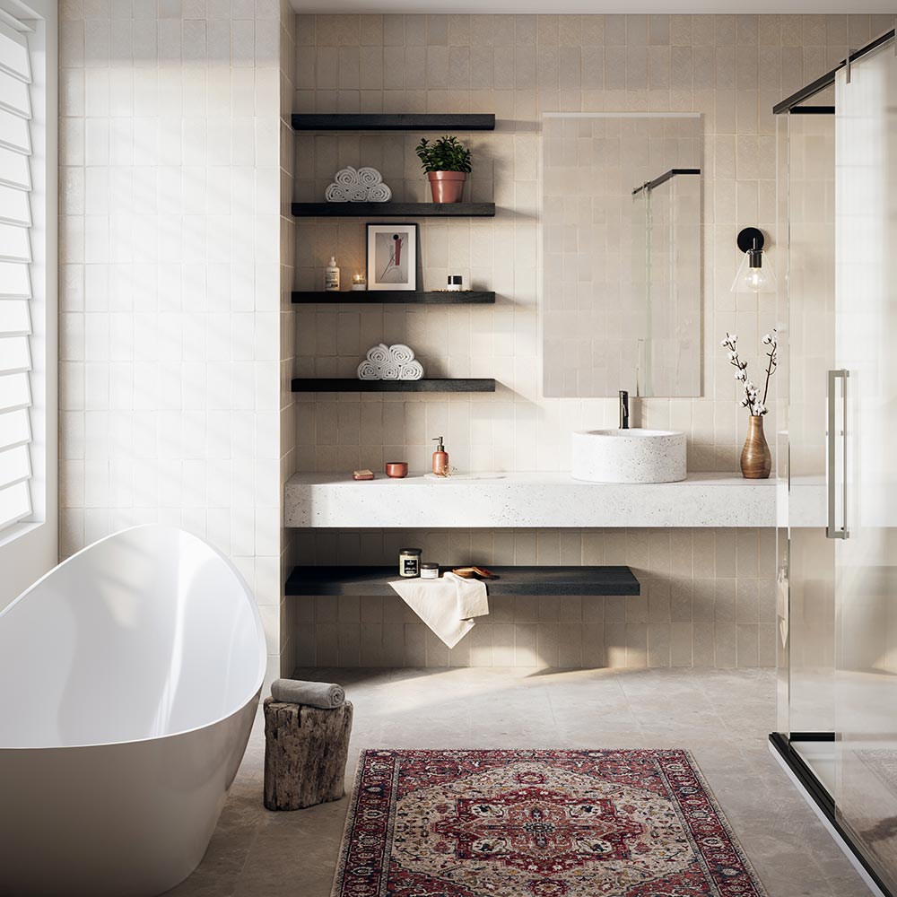 Luxury bathroom with Alma Floating Wall Shelves in matte black finish, styled with rolled towels, potted plant, candles, and framed art above a stone vanity with vessel sink, adjacent to a freestanding bathtub and glass shower.