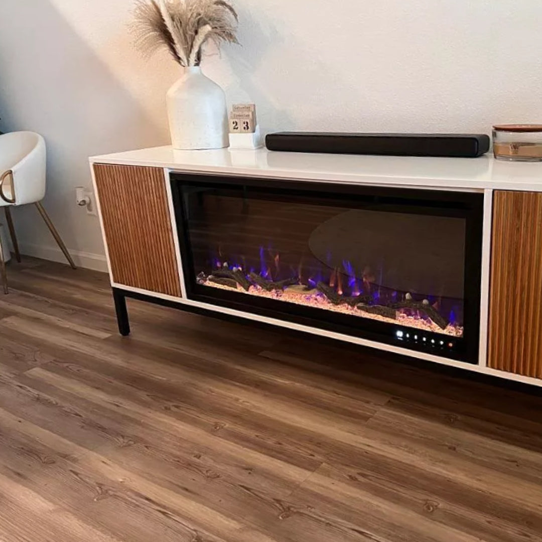 Customer image color-changing flame electric insert built into modern TV stand with black legs and warm-toned wood accents by Modern Ember