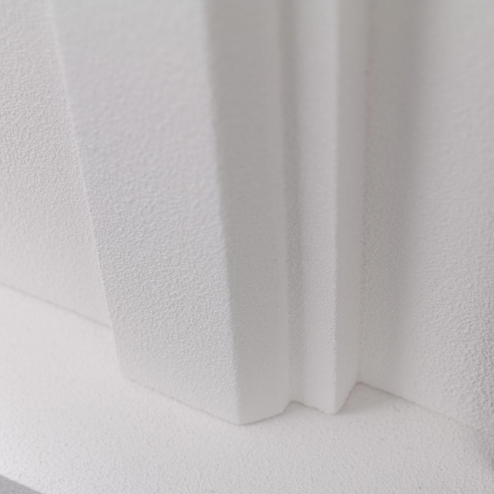 Close-up of the white premium cast stone mantel material, showing the fine stucco texture.