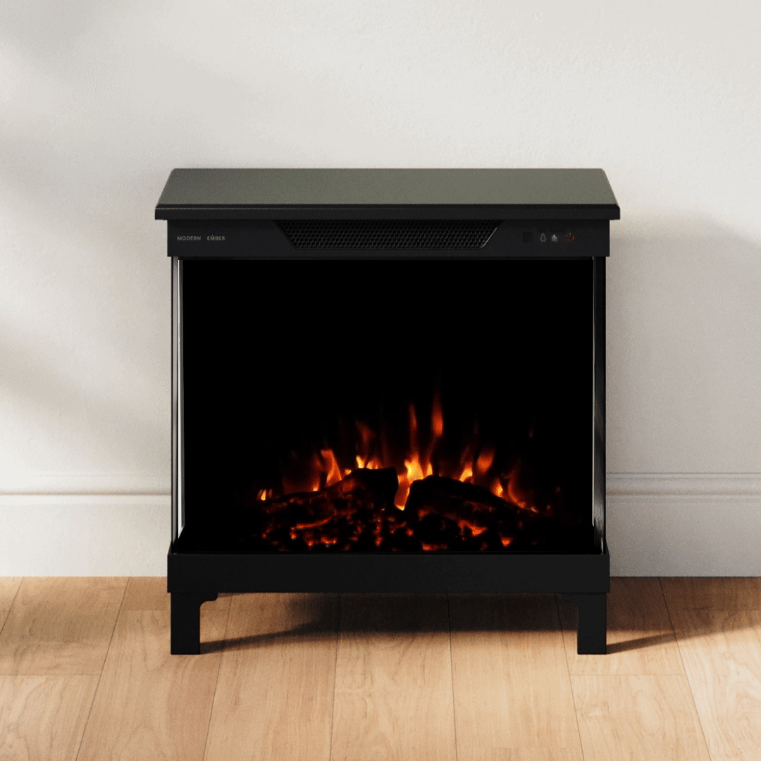 24-inch Skyline Smart 3-Sided Freestanding Electric Stove in a black all-metal body, showcasing the realistic fire display and log set from the front.