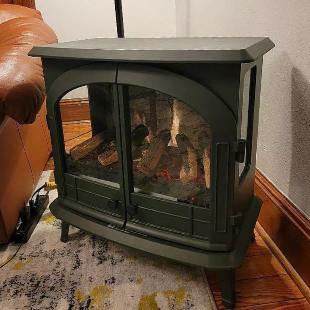 customer image of Modern Ember freestanding electric fireplace stove with realistic log set and dual glass doors, styled in a warm living room corner—blending traditional charm with efficient electric heating by Modern Ember.