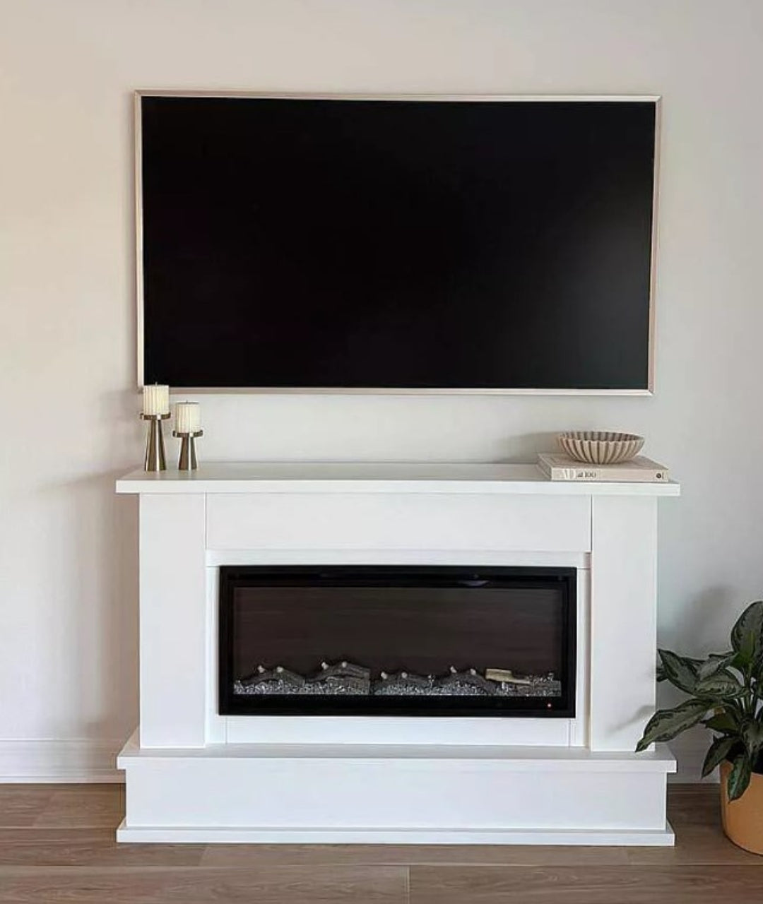 Customer image of electric fireplace with mantel kit decorated, with TV above.