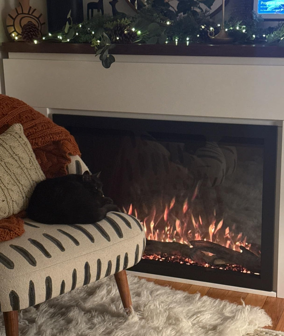 Customer image of electric fireplace with white mantel package and cat sitting in front of the fireplace.