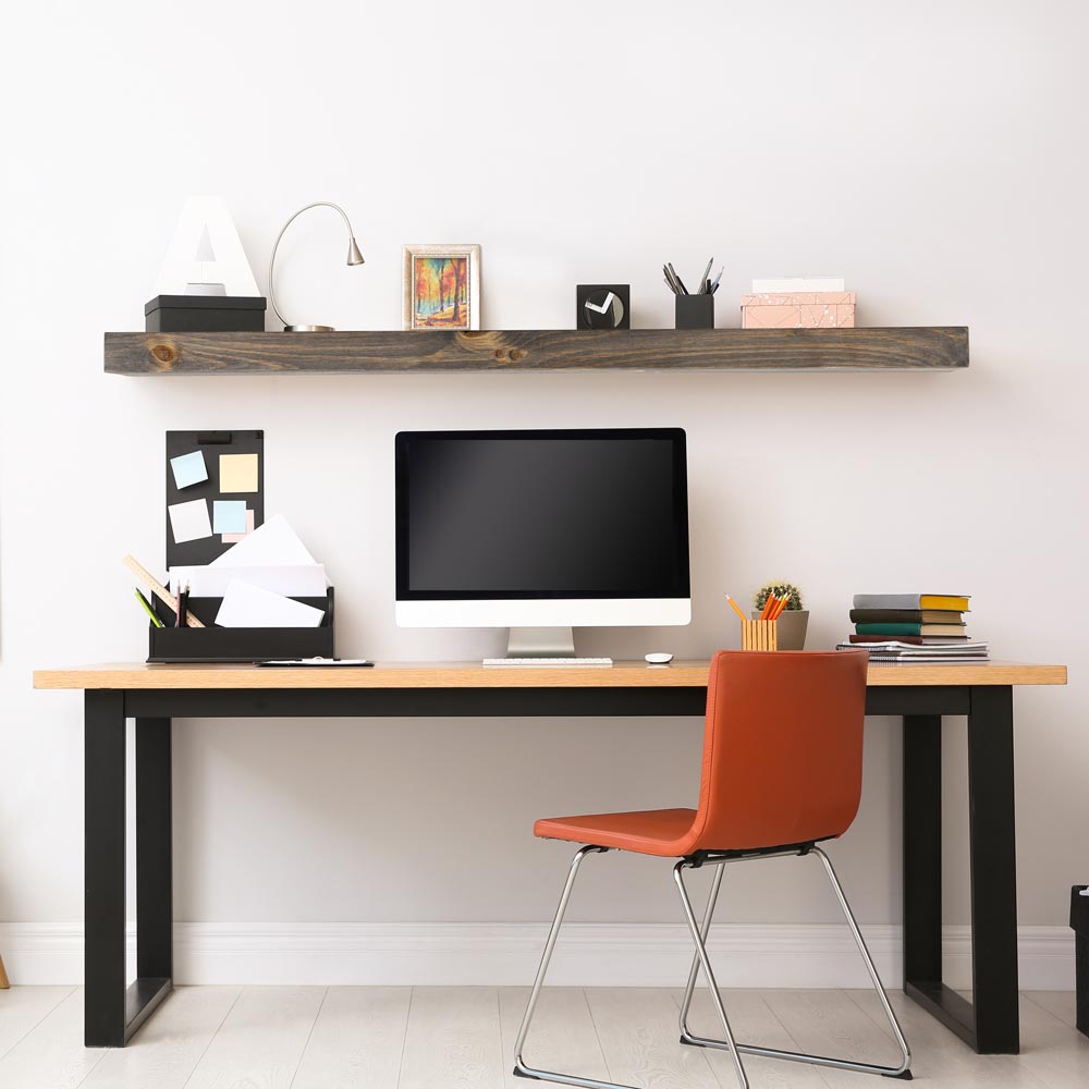 Modern Ember Vara floating shelf anove computer desk. Vera floating shelf has office decor on it.