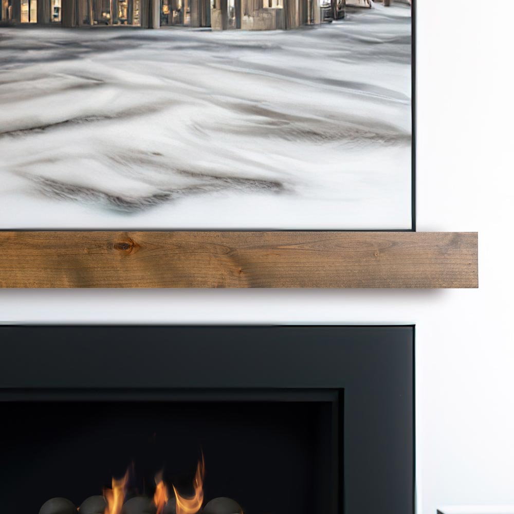 Modern Ember floating fireplace mantel shelf in natural wood finish installed beneath wall-mounted TV