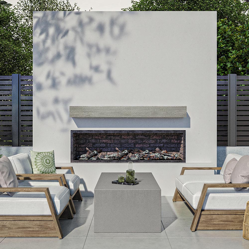 Alpine 60-inch Concrete Mantel Shelf in Fog finish, installed on an outdoor modern fireplace surround, styled with cushioned wooden lounge chairs and a concrete coffee table in a contemporary patio setting.