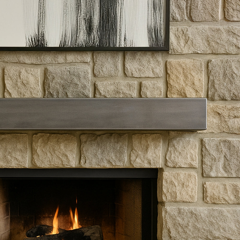 close up view of Lustra Metal Mantel Shelf in silver birch finish floating above a black fireplace and rustic stone hearth. Modern industrial style.