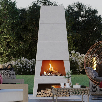 Wide shot of an outdoor entertaining space featuring the Kairo Fireplace centerpiece, demonstrating its wood-burning fire.