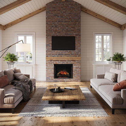 Living room with a brick fireplace with 33 inch uptown insert, gray sofas, and a wooden coffee table.