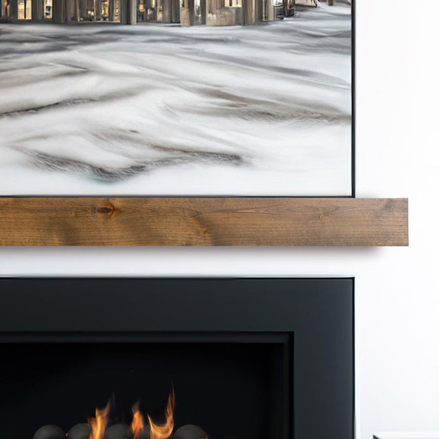 Modern Ember floating fireplace mantel shelf in natural wood finish installed beneath wall-mounted TV