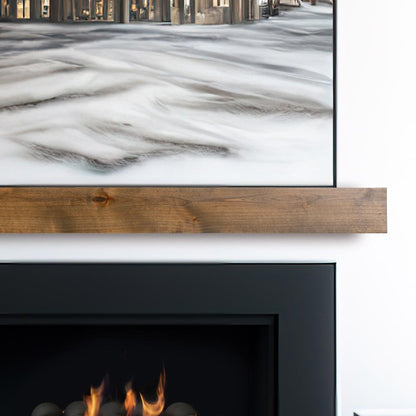 Modern Ember floating fireplace mantel shelf in natural wood finish installed beneath wall-mounted TV